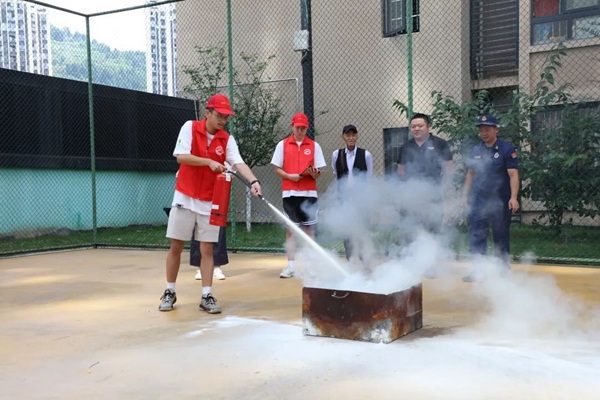 大學(xué)生參與學(xué)習(xí)如何正確使用滅火器。石柱縣消防救援大隊(duì)供圖