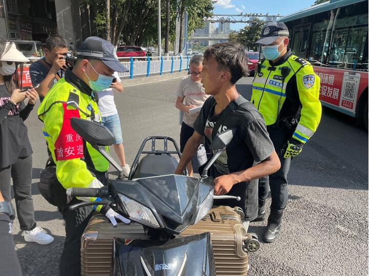 民警在街頭勸導(dǎo)摩托車駕駛員。實習生越倚航攝