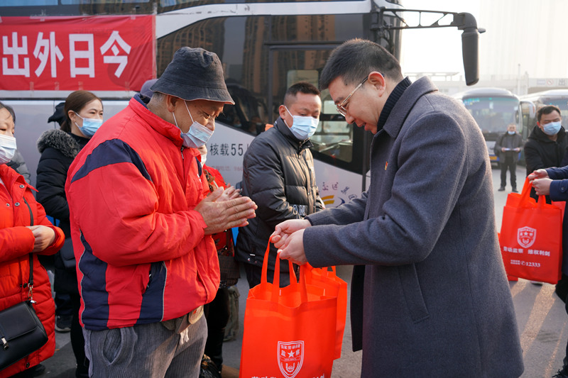 工作人員為返崗務工人員送去新春祝福。唐敖攝