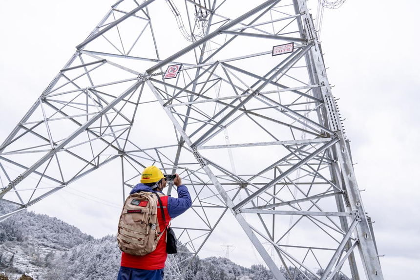 2月9日，在彭水縣中嶺山，國(guó)網(wǎng)重慶電力員工對(duì)電力線路開(kāi)展冰雪特巡。牟偉攝