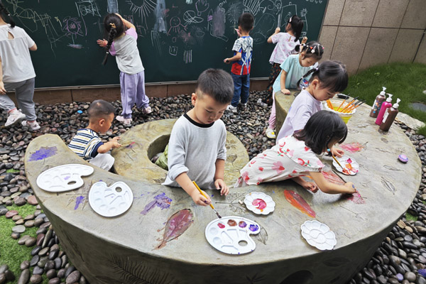 孩子們創(chuàng)作樹葉拓印水泥桌現場。二師附二幼供圖