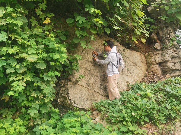 《認(rèn)識節(jié)理與裂隙》。7月17日，川東南勘察公司地災(zāi)精細(xì)化調(diào)查人員夏頂洪對沙坪壩區(qū)白楊溝滑坡右側(cè)基巖節(jié)理裂隙進(jìn)行測量。徐騰攝