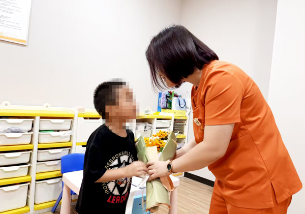 孩子給老師送上鮮花。重慶小米熊兒童醫(yī)院供圖